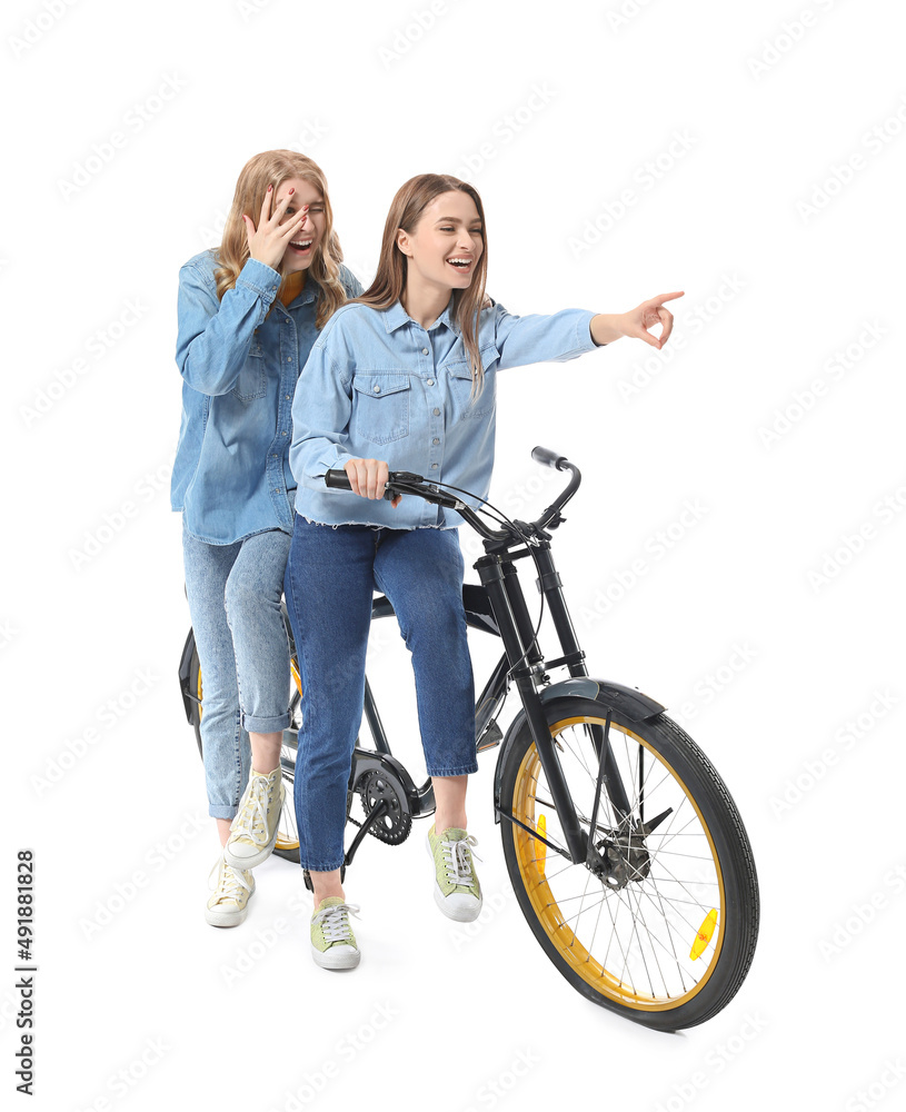 骑自行车隔离在白色上的快乐年轻姐妹的肖像