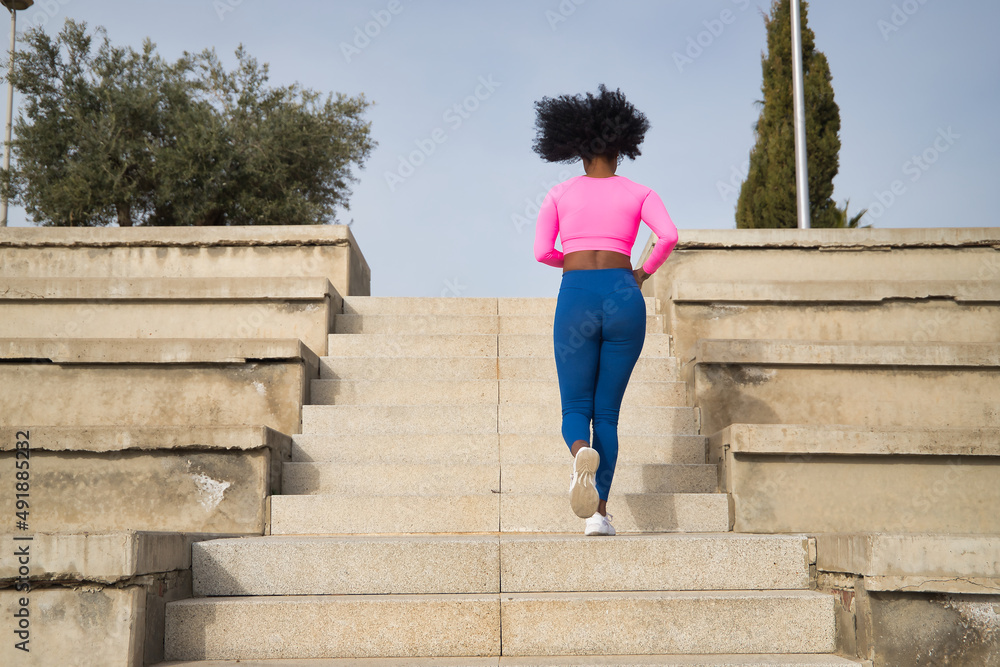 非洲裔美国女性，非洲式头发，运动服，荧光粉色t恤和紧身裤，ru