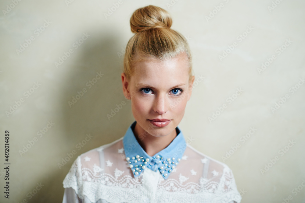 Casual yet stylish. A young woman with her hair in a bun posing in casual wear.
