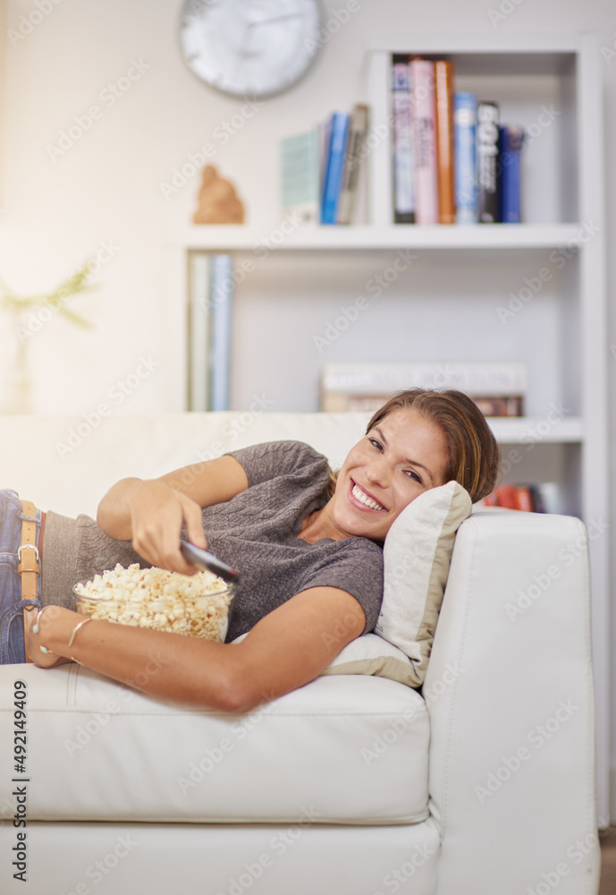 Indulging in a movie marathon. Shot of a young woman spending a relaxing weekend at home watching tv