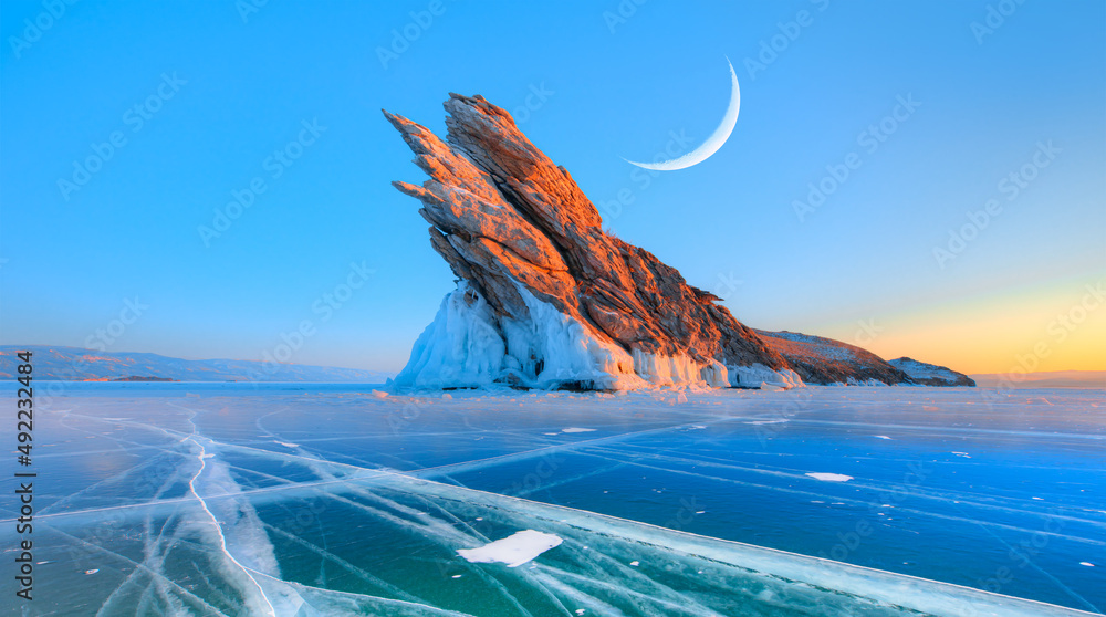 冬季贝加尔湖上的Ogoy岛，背景是日出时透明的蓝色裂缝冰。