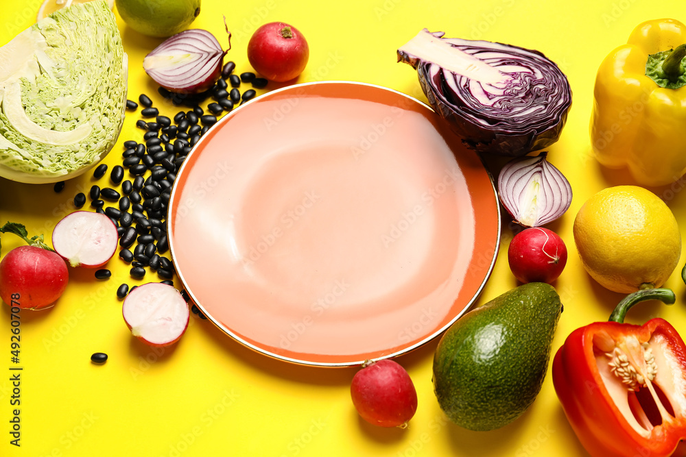 Composition with plate and ingredients for Mexican vegetable salad on yellow background