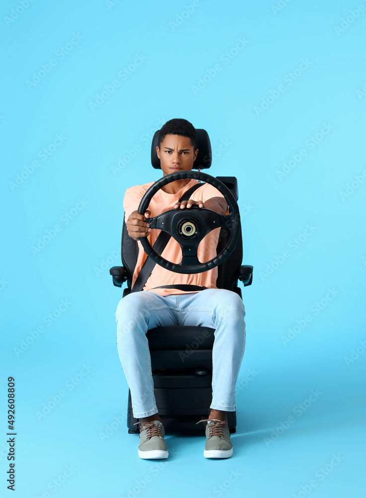 坐在汽车座椅上、方向盘为彩色背景的压力重重的非裔美国人
