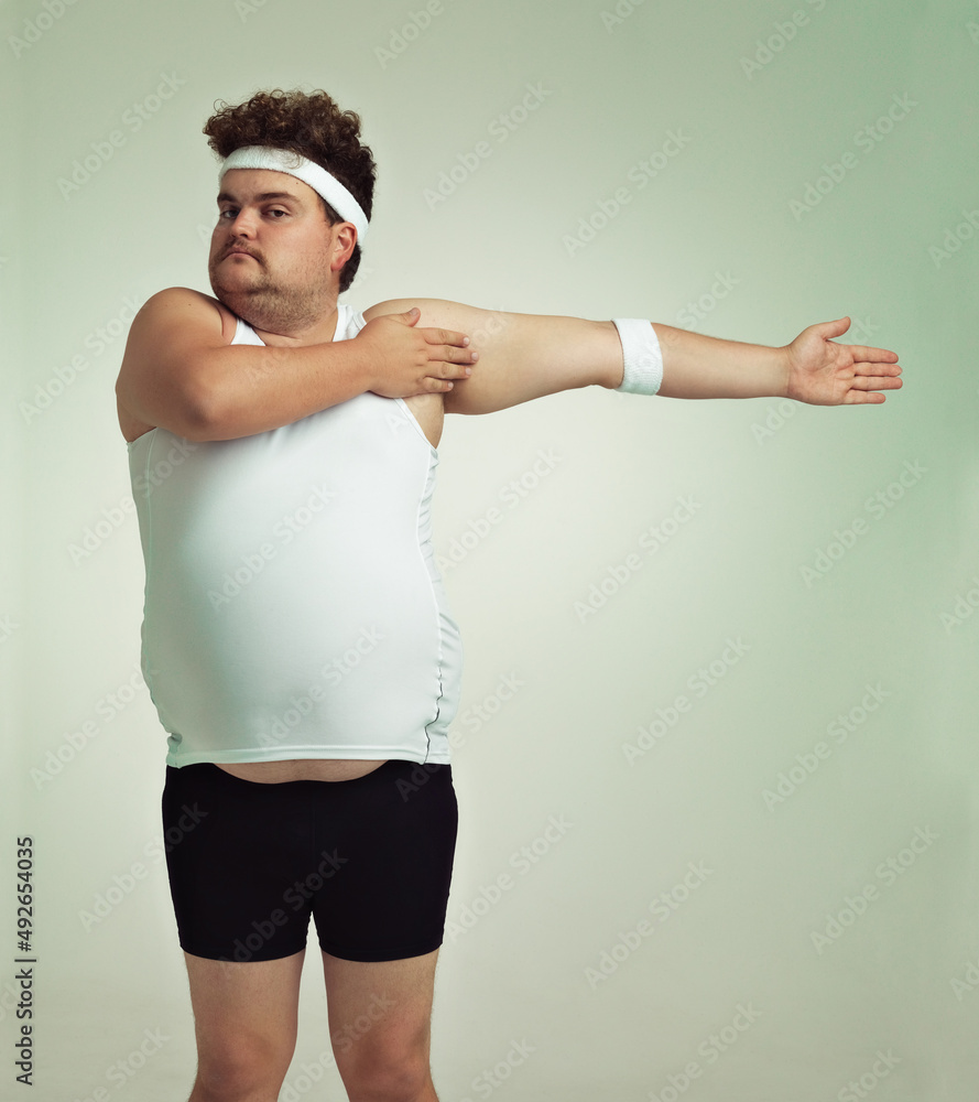Stretching is important. Overweight man doing arm stretches.