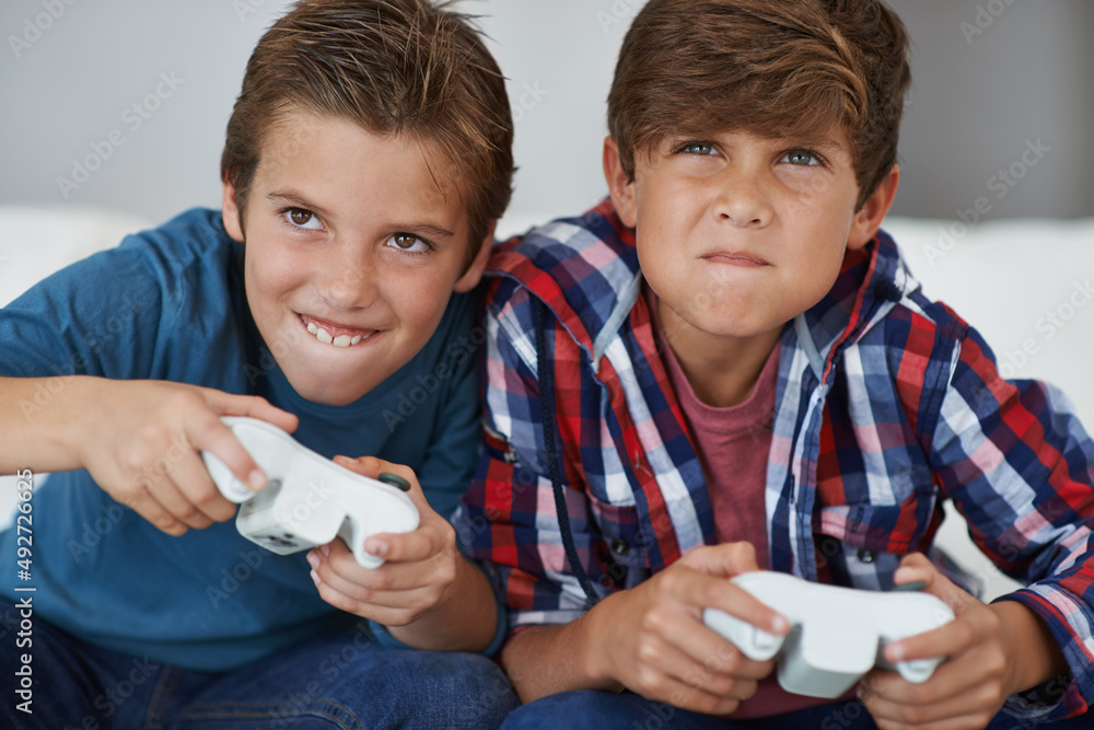 这次我抓到你了。两个小男孩在家玩电子游戏的镜头。