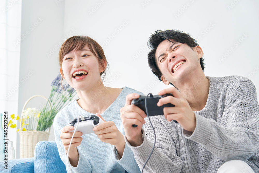 テレビゲームで遊ぶ男女
