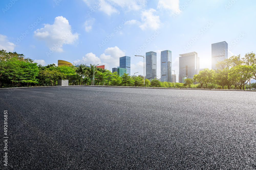 Asphalt road platform and city skyline with modern commercial buildings in Shenzhen, China.