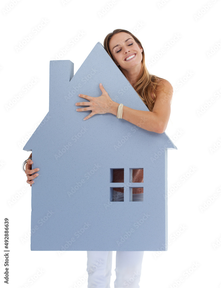 喜欢她的新家。一个年轻女人拥抱一个房子形状的剪纸的工作室镜头。