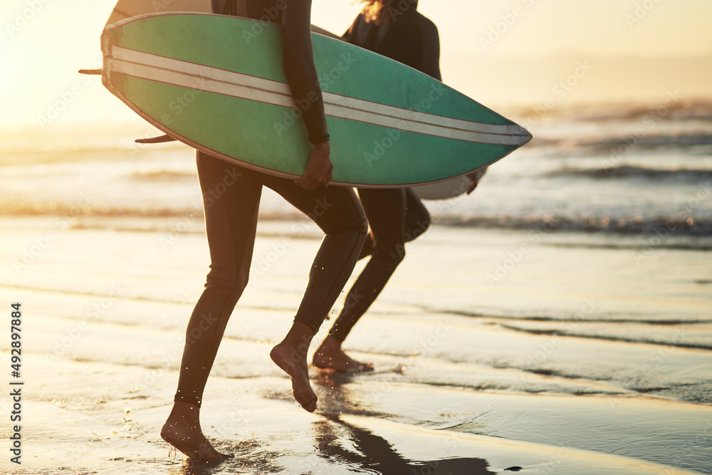 Life is an adventure, live it. Shot of an unrecognizable young couple going surfing at the beach.