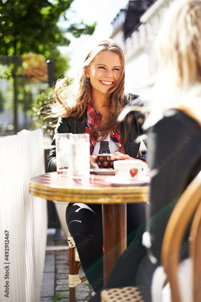 赶上一个老朋友。两个年轻的女朋友在咖啡馆喝咖啡聊天。