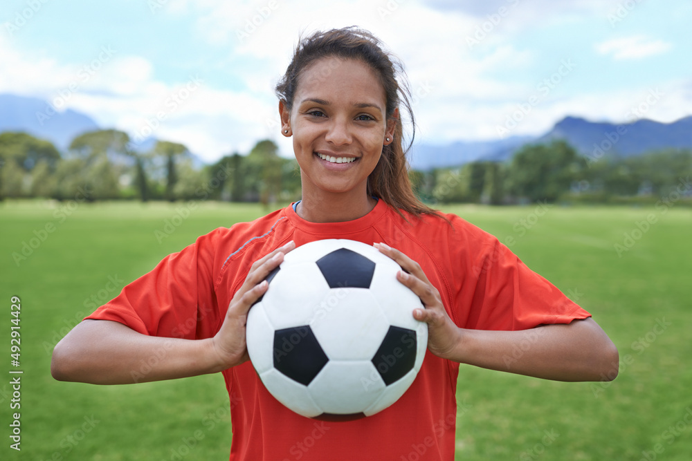 为了胜利。一名年轻女子足球运动员拿着足球的镜头。