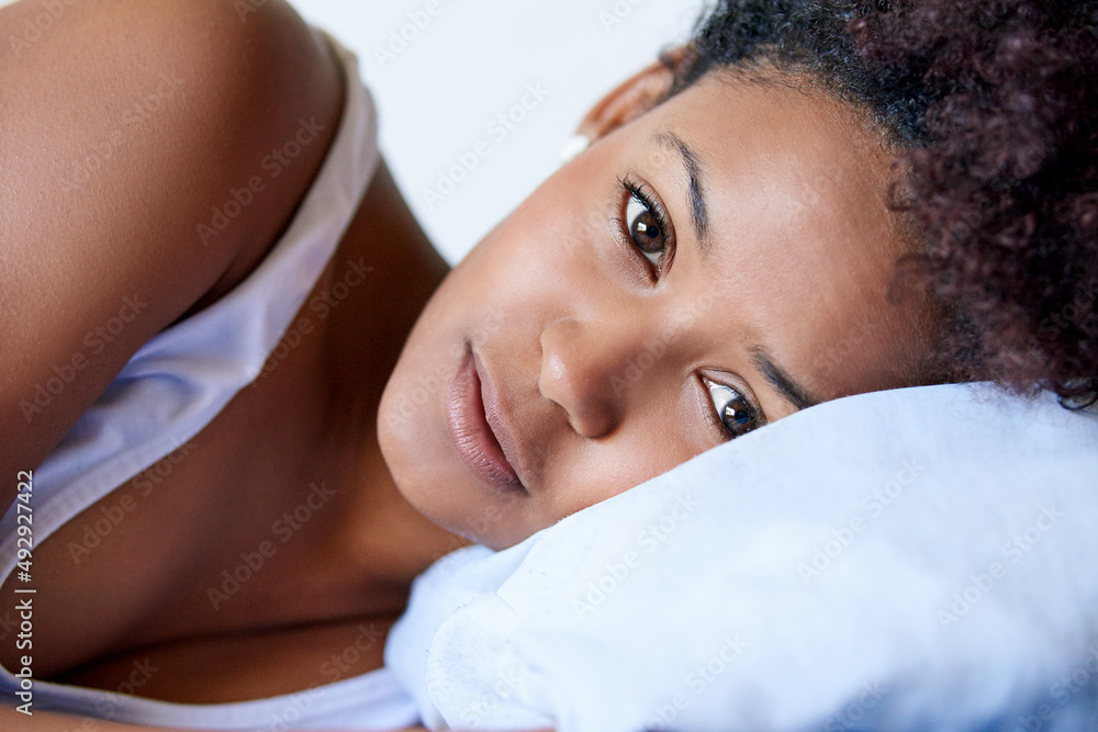 Sometimes you just dont wanna get out of bed. Closeup shot of a young woman lying down on a pillow a