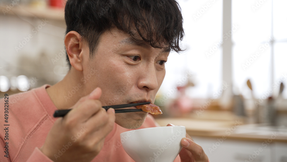 在h餐厅用筷子享用美味肉类的头脑发热的亚洲男子特写