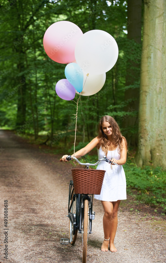感觉有点异想天开。一个漂亮的年轻女人拿着一堆气球和一辆自行车在t里行走