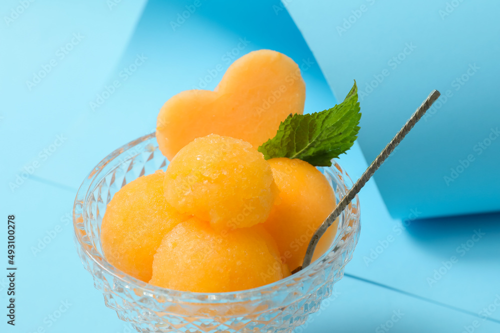 Bowl with tasty melon sorbet on blue background