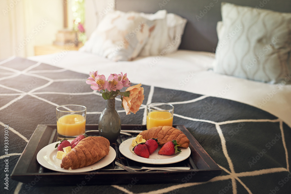 没有什么比床上早餐更好的了。在床上吃早餐的托盘照片。