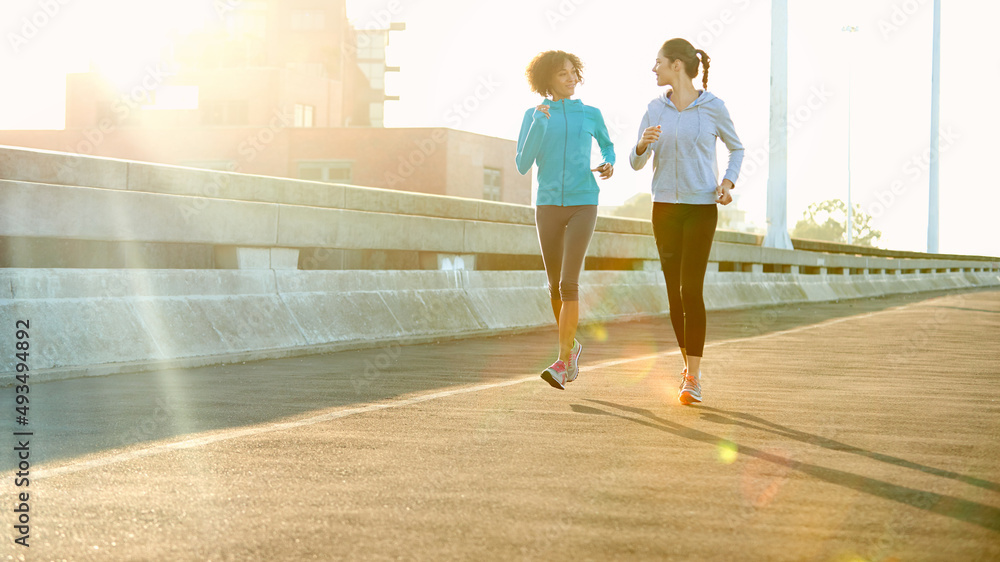 喜欢晨跑。两个朋友在城市里一起慢跑的照片。
