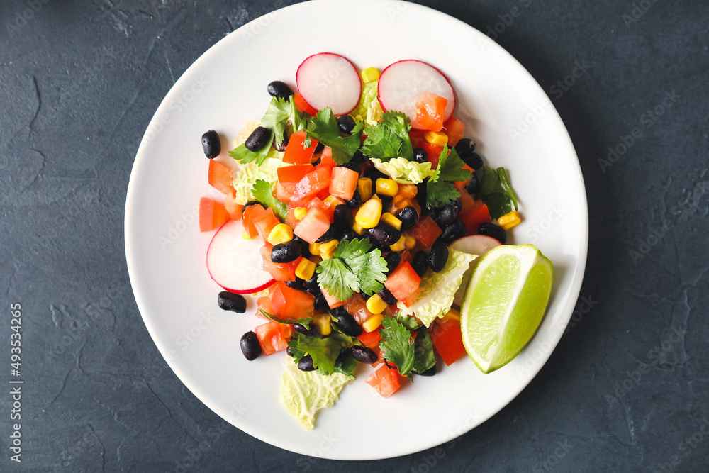 一盘墨西哥蔬菜沙拉，黑底黑豆和萝卜，特写