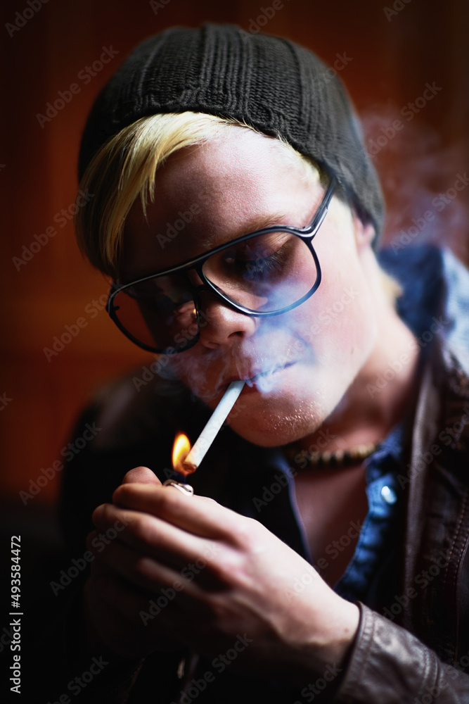 养成坏习惯。穿着都市装的年轻人点着烟。