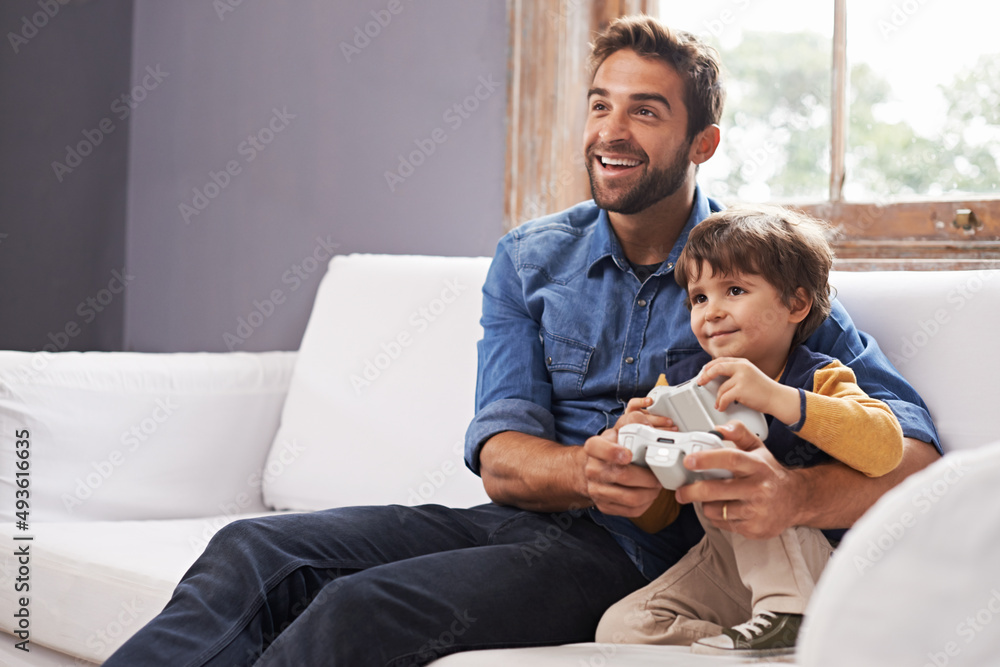 Im beating you dad. A handsome father and his cute son playing a video game together.