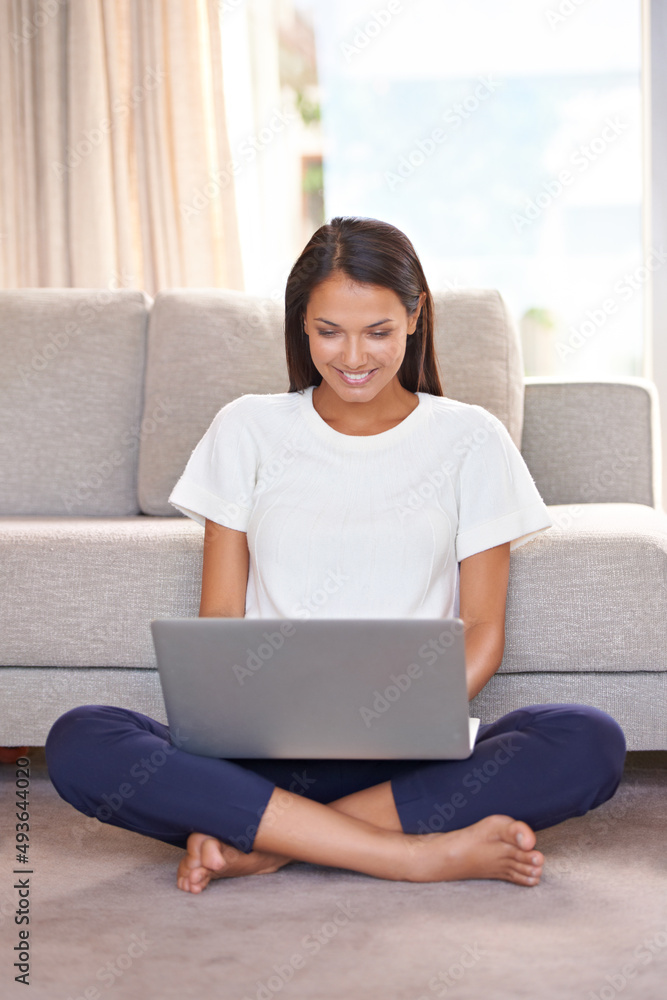 和她的网友一起放松。一个漂亮的年轻女人在家里用笔记本电脑的照片。