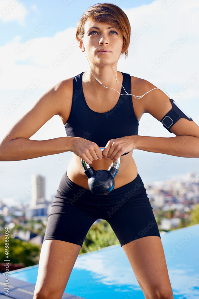 享受有节奏的锻炼。一个女人拿着哑铃锻炼的镜头。