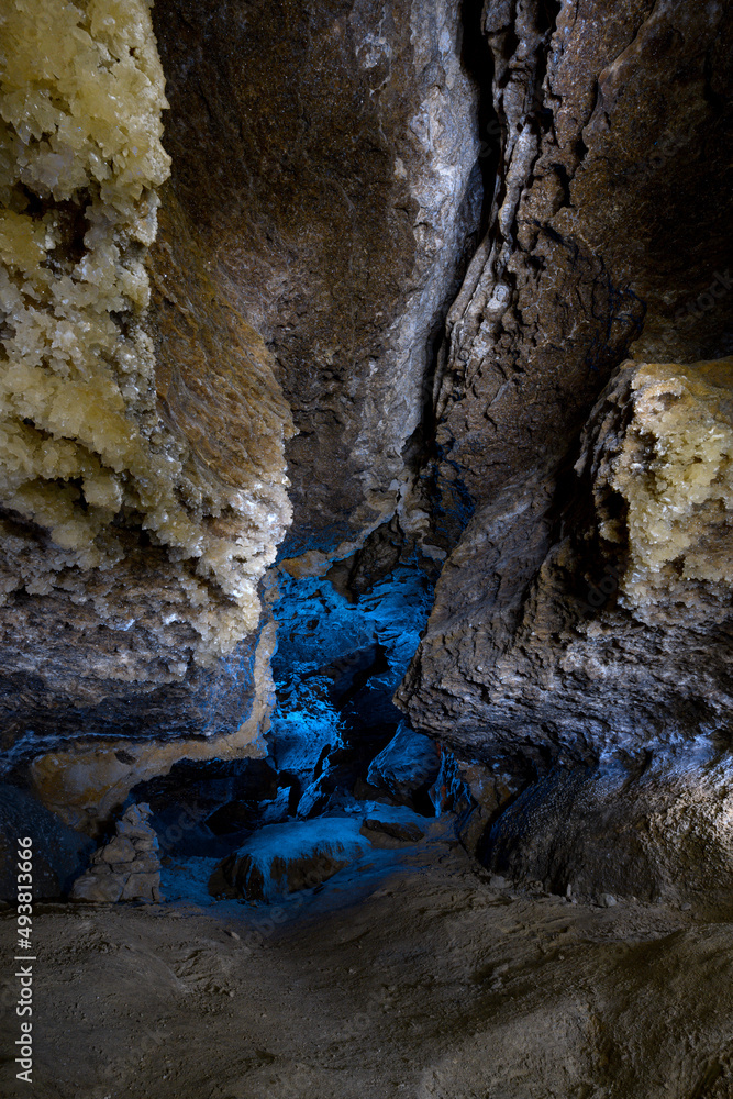 洞穴内部有蓝光和水晶。旅游徒步旅行路线。古老的石头结构
