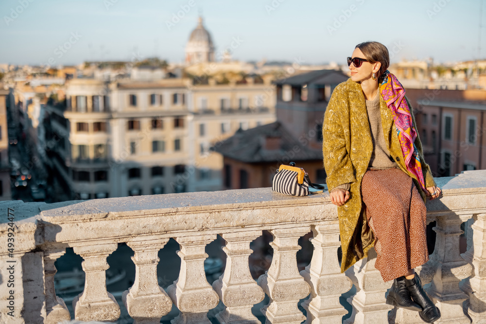 Woman enjoying beautiful morning cityscape of Rome, sitting on the top of famous Spanish steps. Old 