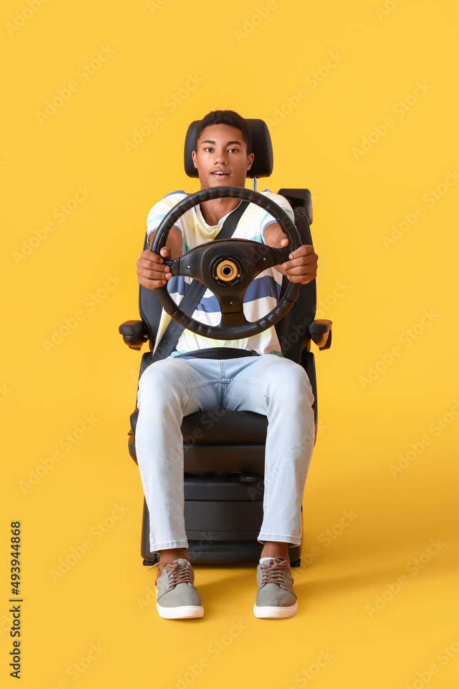 非裔美国人坐在汽车座椅上，方向盘为彩色背景
