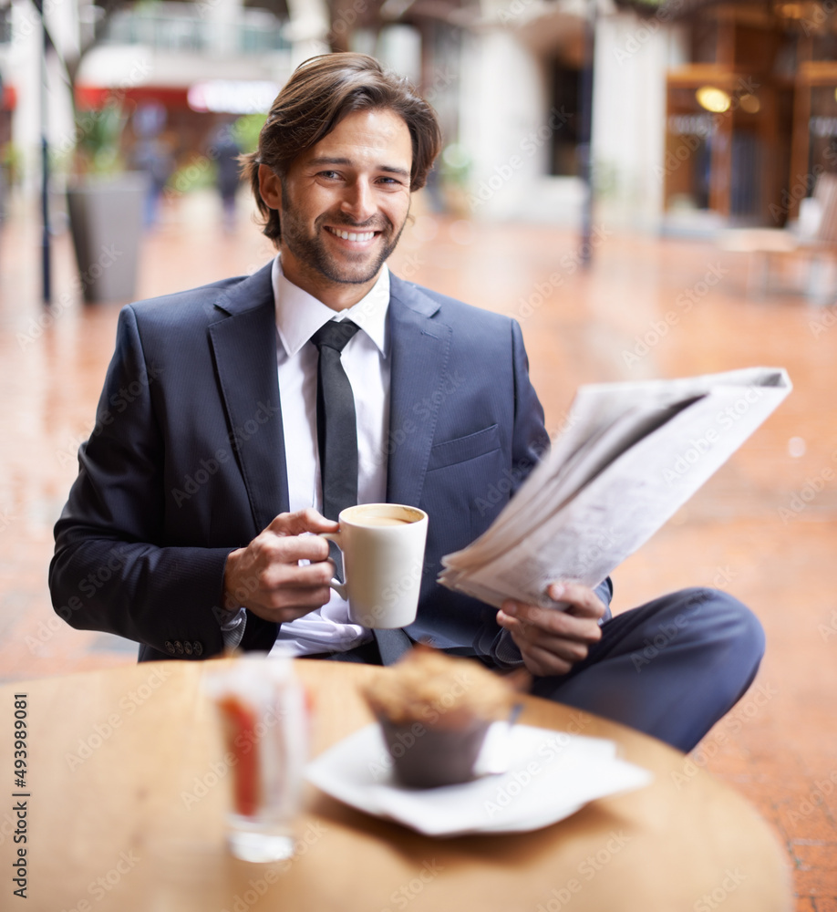 在忙碌的一天中给自己一些时间。一位商人在阅读《泰晤士报》时喝咖啡休息