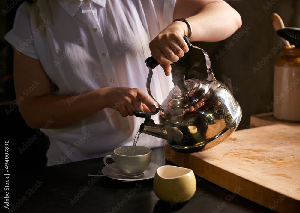 酿造完美的杯子。一个年轻女人在厨房里泡茶的裁剪镜头。