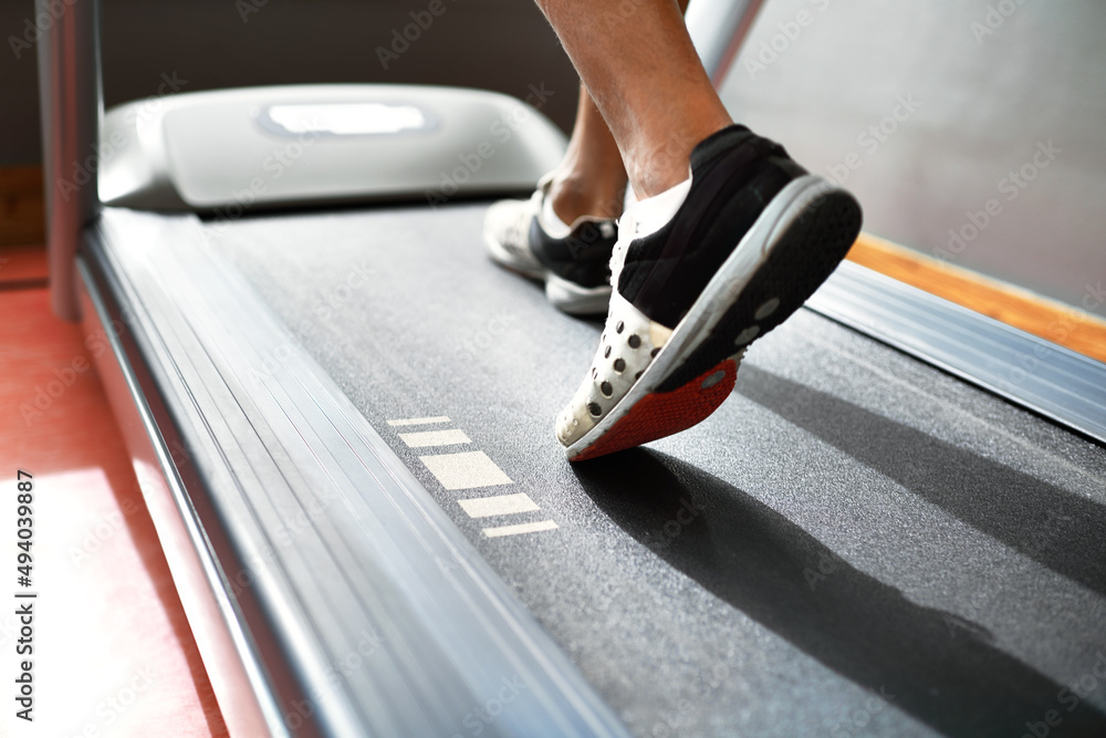 跑步保持健康。健身房跑步机上一名男子的特写镜头。