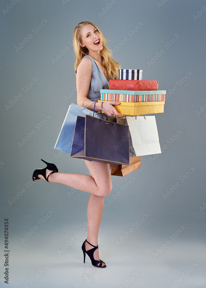 I can stop any time I want. Full length studio shot of a happy young woman holding a selection of sh