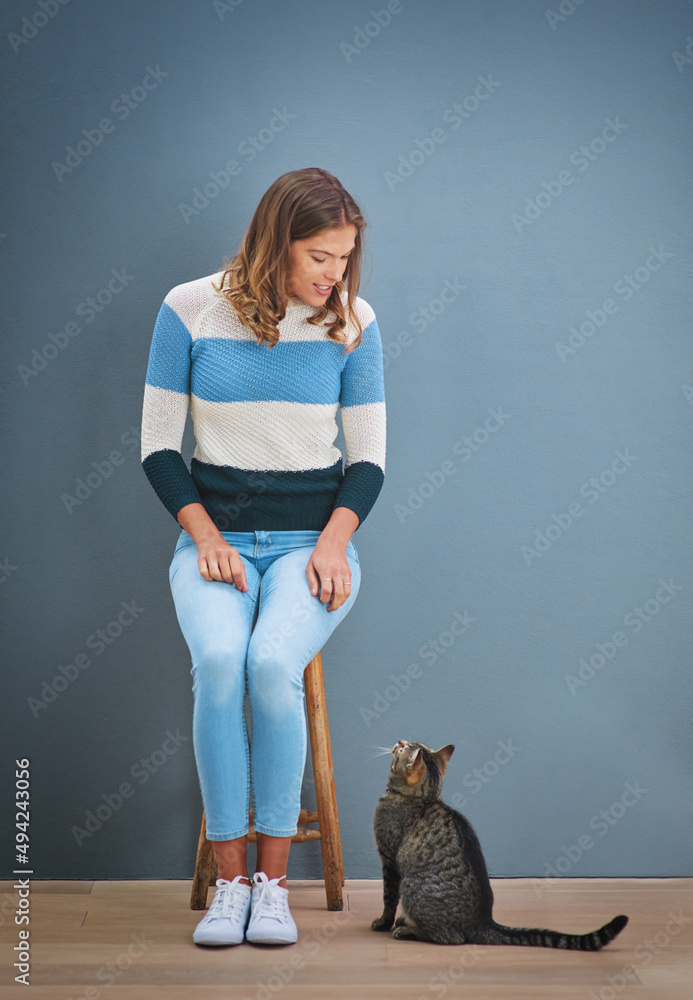 嗨，凯蒂。一个年轻女人看着一只猫的镜头。