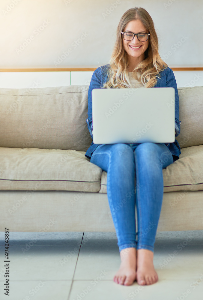 在互联网上获取周末剂量。一张有魅力的年轻女子坐着用笔记本电脑的照片