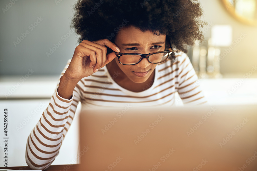 我读对了吗？一个专注的年轻女人拿着她的r在笔记本电脑上工作的镜头
