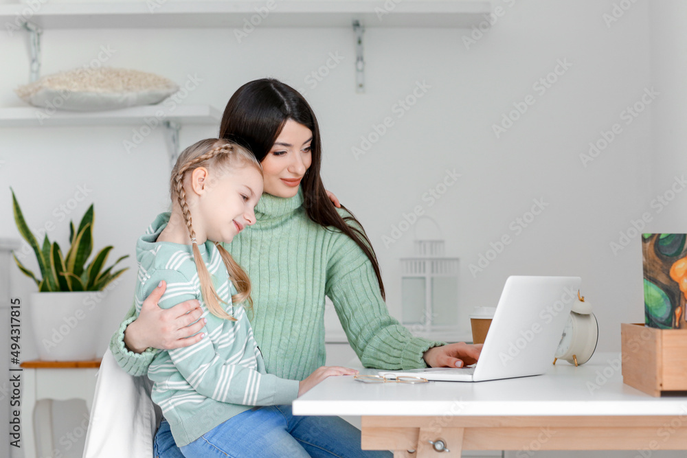 快乐的小女孩和穿着保暖毛衣的妈妈在家视频聊天