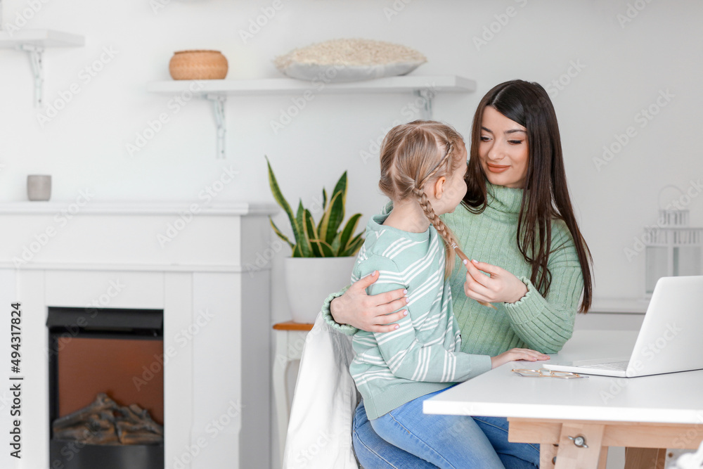 快乐的小女孩和她穿着温暖毛衣的妈妈坐在家里