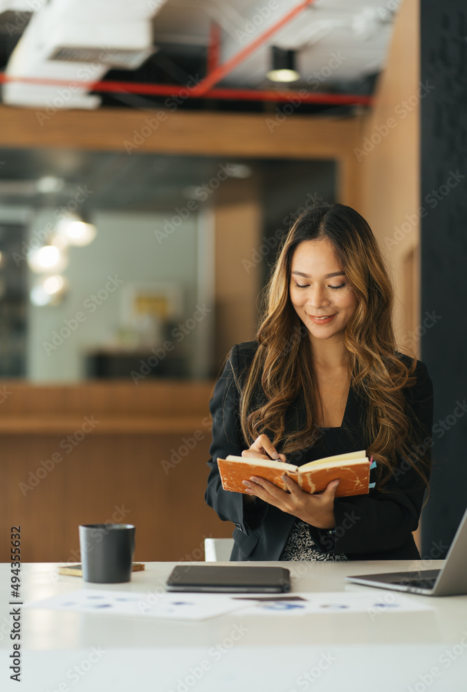 business asian woman hand taking notes with various items placed on the office table. online meeting