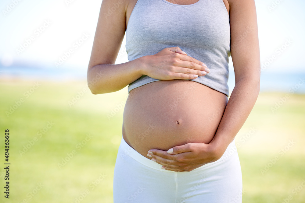 怀孕期间保持身体健康。孕妇穿着运动服的裁剪镜头