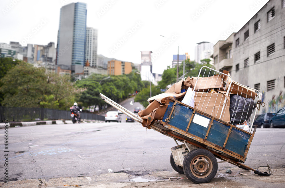 运输垃圾。一辆装满垃圾的手推车在贫困城市的街道上拍摄。