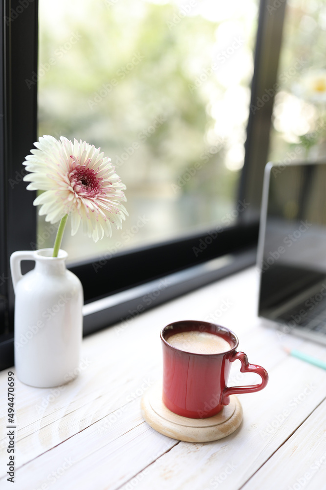 红咖啡杯和非洲菊花