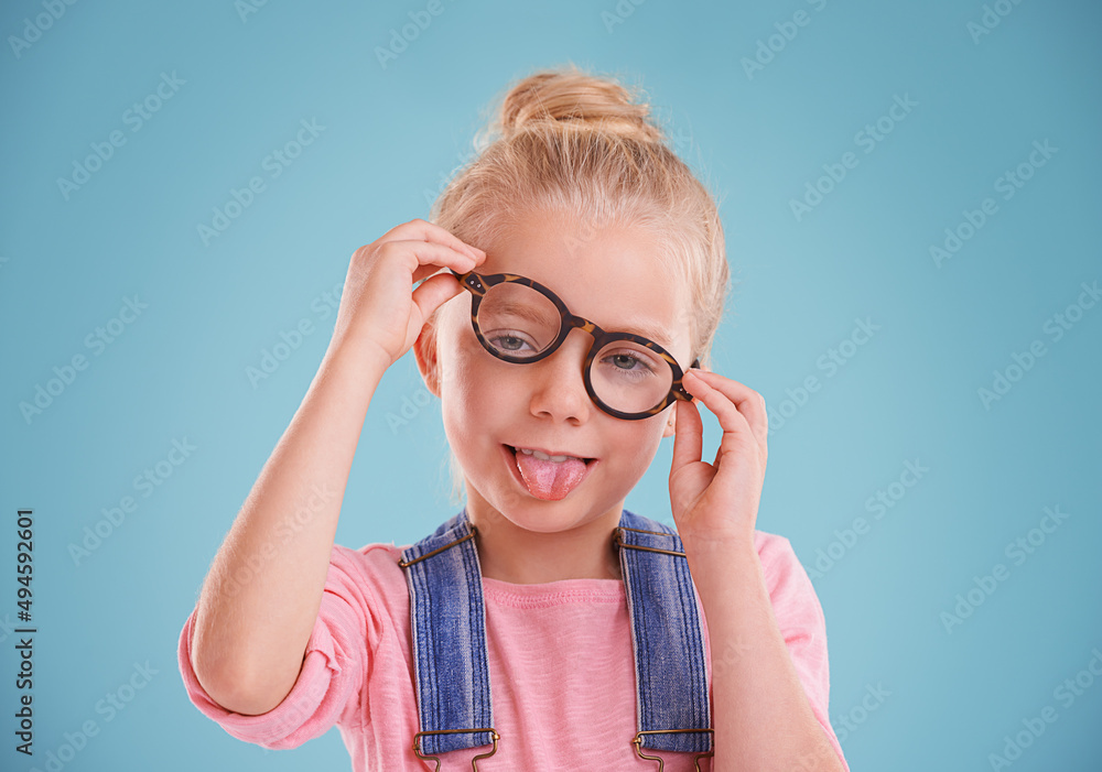These glasses are so funny. Studio shot of a little girl wearing hipster glasses on a blue backgroun