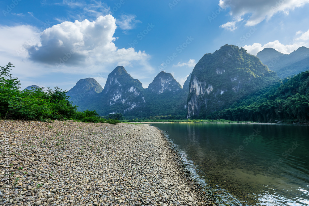 日出时，中国桂林美丽的山脉和卵石海滩与河流。