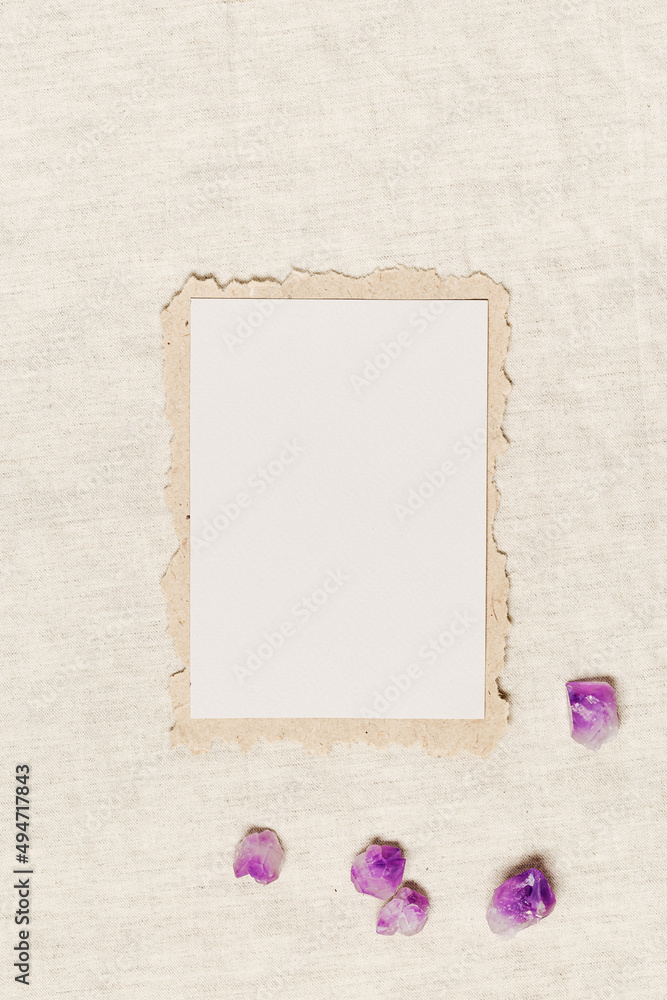 Empty Invitation card, blank card with natural crystal, healing stone purple amethyst on tablecloth 