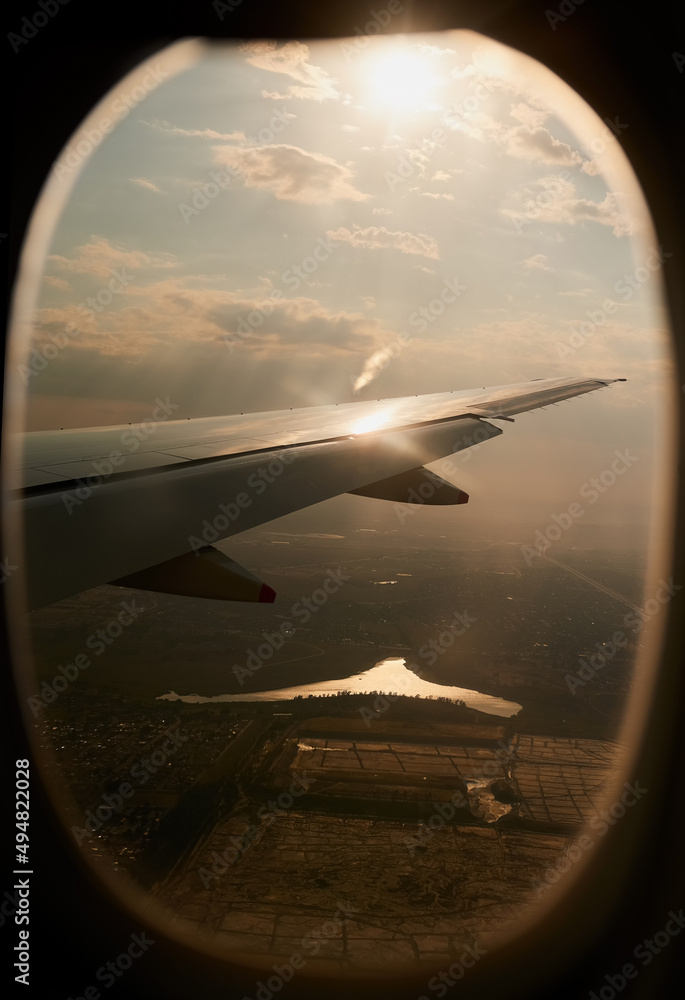 银色翅膀在空中翱翔。从飞机窗户拍摄的景色。