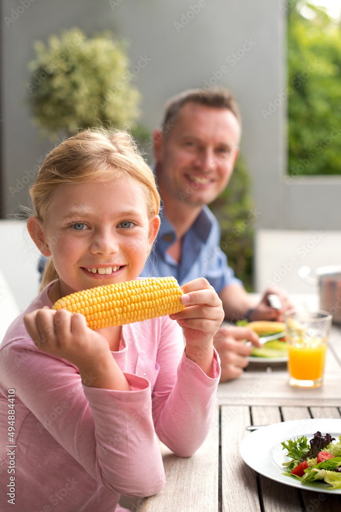 我的最爱。一幅快乐的年轻女孩和她的父亲在户外用餐的画像。