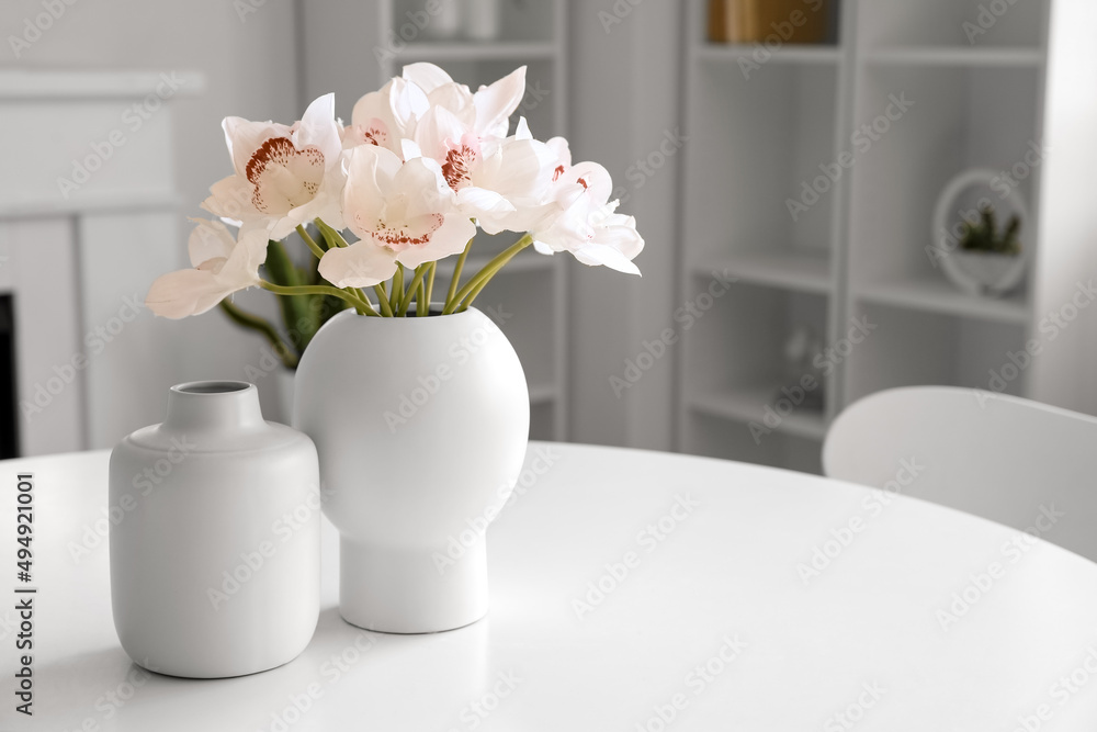 白色桌子上的花瓶和美丽的兰花