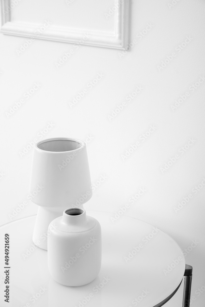 浅色墙壁附近桌子上的白色花瓶