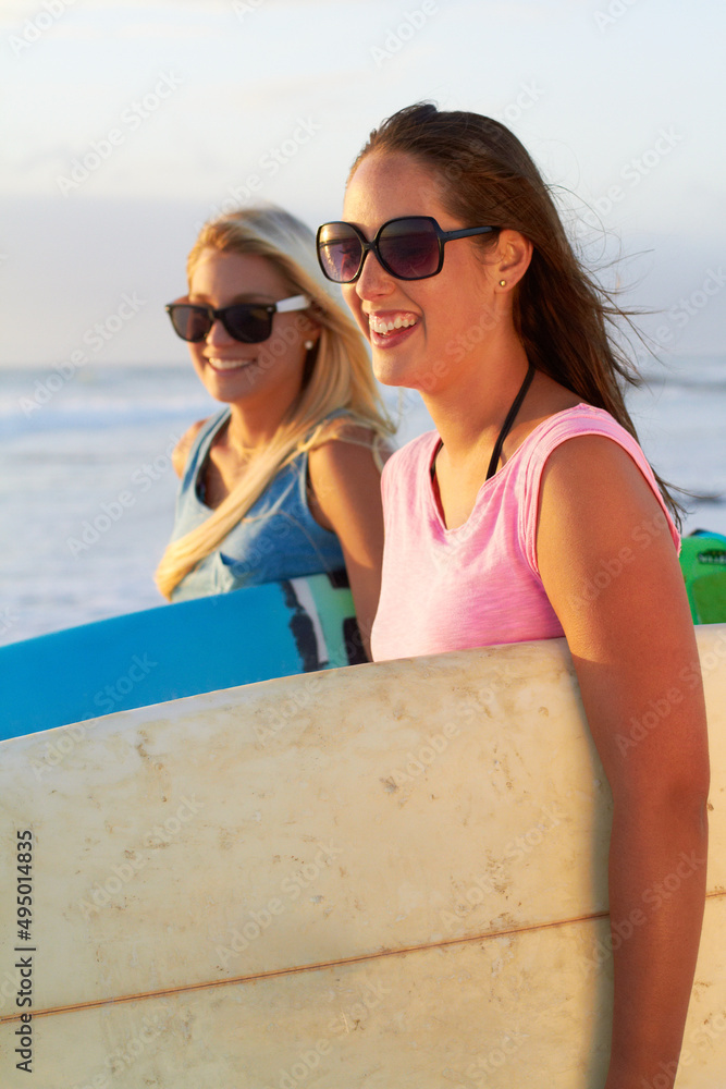 和我的闺蜜一起冲浪。两个有魅力的年轻女冲浪者的裁剪镜头。